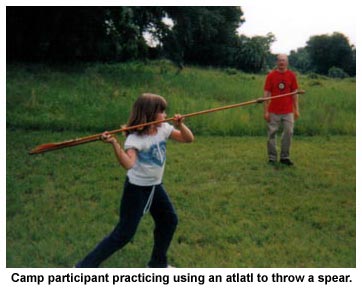 Camp participant practicing using an atlatl to throw a spear. Camp participant practicing using an atlatl to throw a spear.