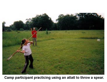 Camp participant practicing using an atlatl to throw a spear. Camp participant practicing using an atlatl to throw a spear.