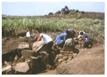 Figure 13. Excavations at the probable sweat house, looking northwest, showing the retention walls of the basal platform, operation EB9. The large rocks on the background stand on a promontory that was part of the obsidian workshop dump. Click to enlarge.