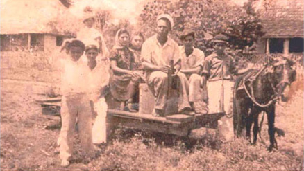 Figure 3c: Photo of a family sitting on a railway truck used when a small-scale railway was developed on the roadbed for the chicle (chewing gum) industry. Photo courtesy of Jorge Sanchez, date unknown.