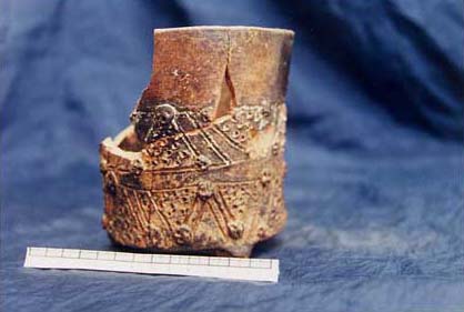 Figure 4b. Photo of the Teotihuac&aacute;n-style blackware cylinder tripod with nubbin supports showing incised decoration in the form of triangular elements with zones of punctate and tiny skull-like appliques.