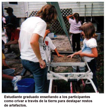 Estudiante graduado ense&ntilde;ando a los participantes como crivar a trav&eacute;s de la tierra para destapar restos de artefactos.